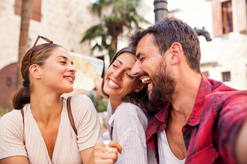 Three happy friends make selfie and smiling