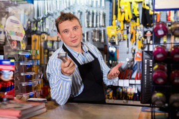 Positive seller standing in hardware shop