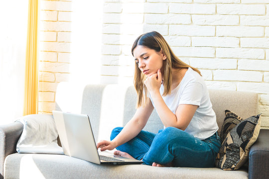 young attractive woman at home tiredly seeking for a job or rent in internet