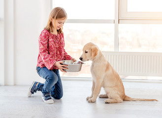 Girl giving food to dog