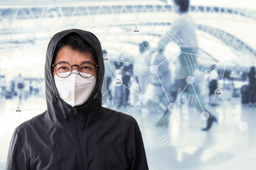 Asian man wearing surgical mask to prevent flu disease Coronavirus with blurred image of people...