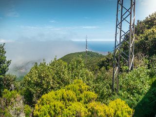 Image of communication metal towers on the mountain top against clear blue sky