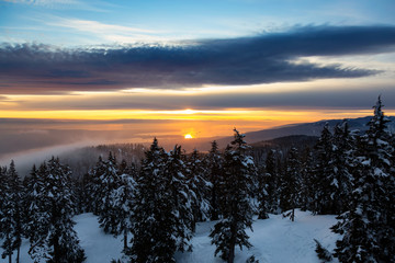 Beautiful Nature Landscape View from the Mountain Top and Downtown City in the Background during a vibrant winter sunset. Taken in Seymour, Vancouver, British Columbia, Canada.