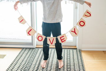 Young child holding a banner that says "I love you"