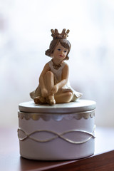A porcelain doll or girl in a dress with a dreamy face. Ceramic statuette ballerina.