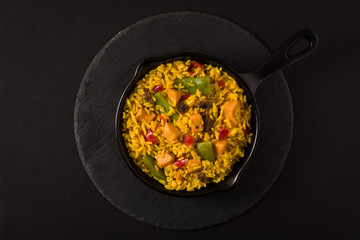 Fried rice with chicken and vegetables on frying iron pan. Top view
