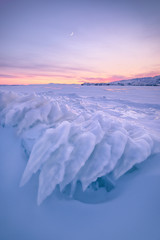 Ice details of the frozen lake Baikal during a winter sunset. Irkutsk, Siberia, Russia.