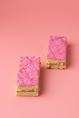 Traditional russian shortbread cakes with jam and pink glazing on bright background