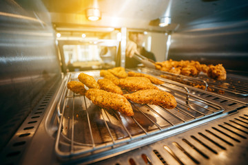 Chef's hand taking Crispy chicken nuggets close-up in a restaurant