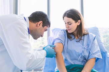 Fototapeta premium Asian doctor Injection vaccines to pretty patient woman with syringe for protect her from sickness