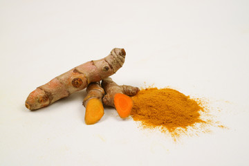 Turmeric powder and turmeric root extracts on a white background are used as a tonic for the body and food ingredients.