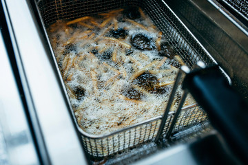 Deep fryer for potatoes in kitchen