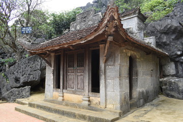 Outdoor park landscape with lake and stone bridge. Gate entrance to ancient Bich Dong pagoda complex. Ninh Binh, Vietnam