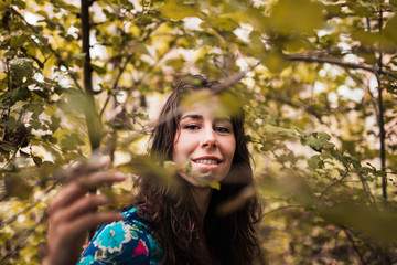 Young smiling woman wearing dress in the forest