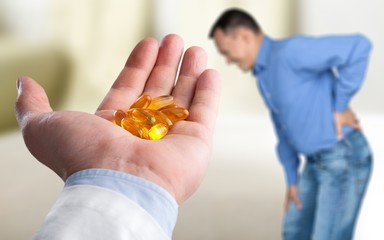 Mature man with awful backache on back and hand with pills