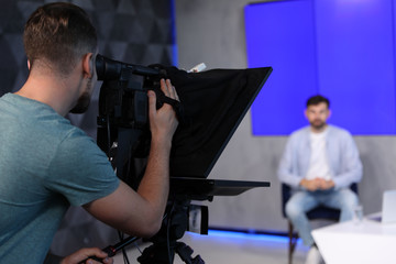 Professional video camera operator working in studio, closeup