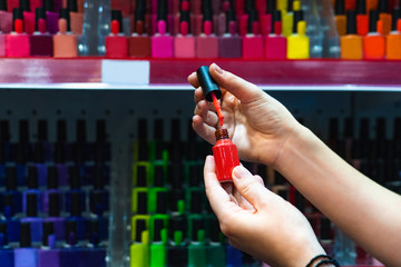 Woman chooses nail polish in a store