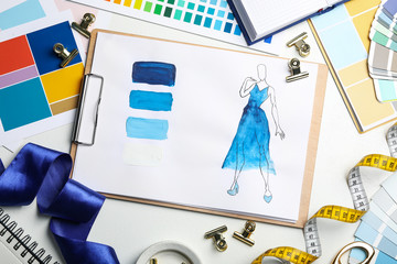 Flat lay composition with drawing of dress on white table. Designer's workplace