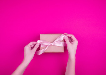 A beautiful gift box with satin ribbon in hand.