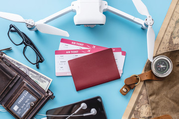 Things for the flight on holiday. Air tickets, passport, phone, credit card, money, drone quadcopter, camera, world map