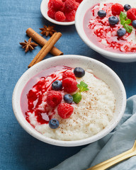 Rice pudding. French milk rice dessert with raspberries, blueberries, berries, jam.