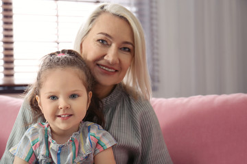 Happy granddaughter and grandmother together at home