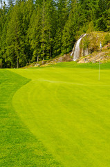 Golf place with gorgeous green and sand bunker.