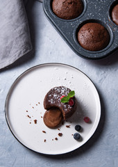 fresh hot vegan chocolate fondant lava with  berries   on a white plate on a blue-gray background