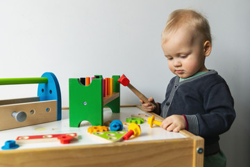 toddler boy playing with toy tool box at home
