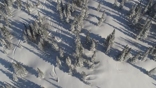 Aerial slow motion: five skiers and one snowboarder ride the first freeride line. off-piste skiing, Heli skiing. freeriders roll out large untouched snow valleys. Freeride ski & Epic free ride scene