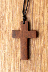 Wooden cross on wooden background