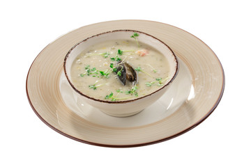Garlic cream soup with mussel and micro greens in grey bowl isolated on white background