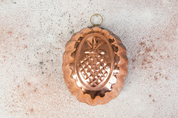 Vintage copper mold on a concrete background.