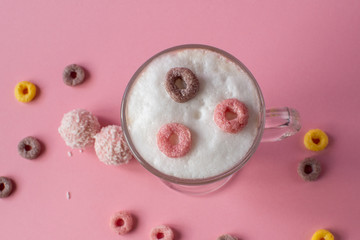 Cappuccino in a glass with bright colorful candies. still-life. coffee.