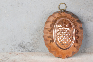 Vintage copper mold on a concrete background.
