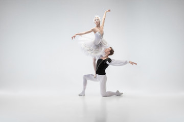 The moon. Graceful classic ballet dancers dancing isolated on white studio background. Couple in tender white clothes like a white swan characters. The grace, artist, movement, action and motion