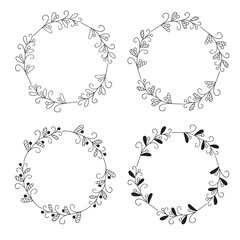 Wreaths of leaves and twigs. Set of four black and white vector round floral frames isolated on a white background.