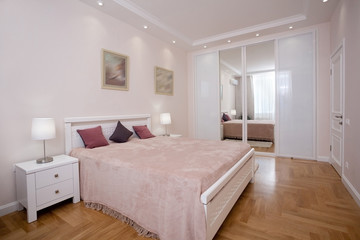 empty minimalistic interior background, bedroom of modern apartment with big mirrors, double bed, lights on
