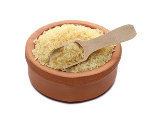 Parboiled rice pile in wooden spoon and clay pot isolated on white background