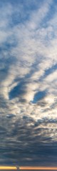 Fantastic clouds at sunrise, vertical panorama