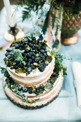 Details of the wedding day. Wedding two-tier biscuit cake decorated with black currants close-up.