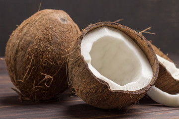 Coconut, chopped in half coconut on dark wooden background