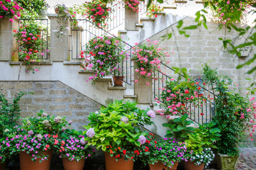Fototapeta premium Italy. Exterior stairs of a cottage in the Tuscan countryside decorated with multicolored flower pots