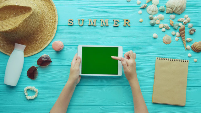 Top View Mockup Of Woman Hands Holding Digital Tablet With Green Screen, Summer Accessories. Summer Holiday Beach Banner Background, Travel Summer Concept