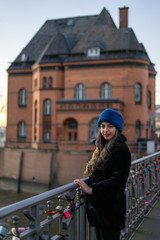 Middle eastern young female model in the beautiful port of hamburg during sunset.