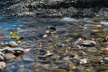river with a stream and pebbles.pebbles at the bottom of the river