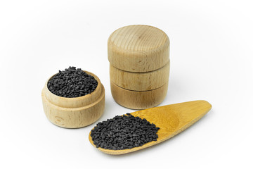 Black Sesame seeds in wooden bowl and spoon isolated on white background.Organic natural sesame seeds and extract oil concept