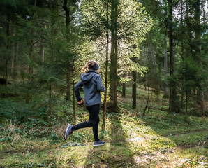 a woman jogging through the woods