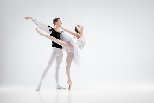 Direction. Graceful classic ballet dancers dancing isolated on white studio background. Couple in white clothes like a white swan characters. The grace, artist, movement, action and motion concept.