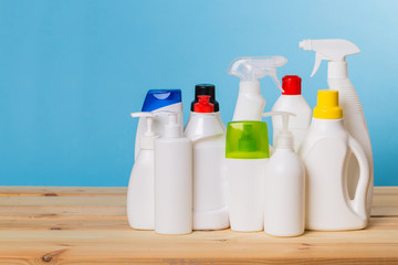 Cleaning product plastic container for house clean on wooden table and blue background . household chemicals
